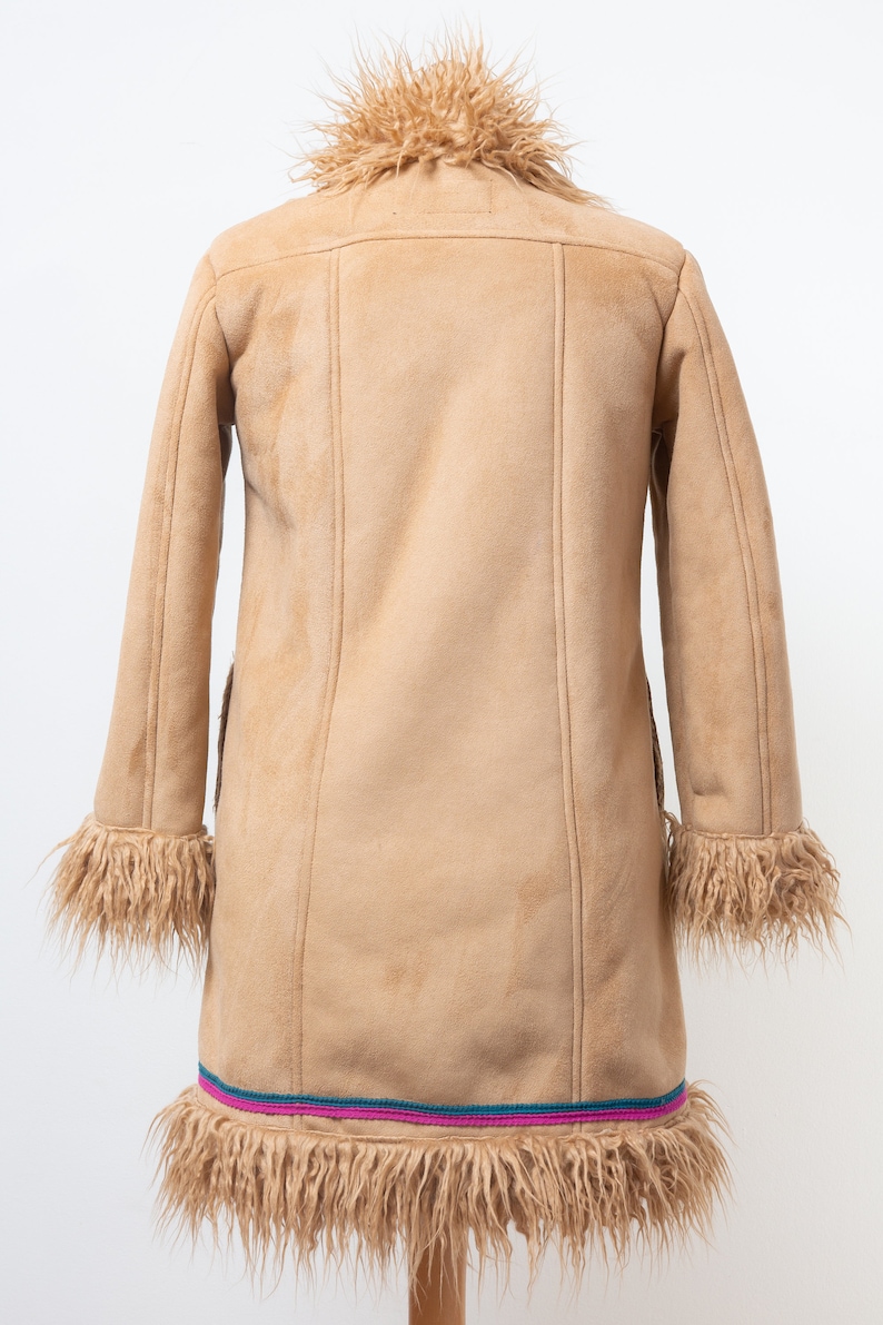 May include: A brown suede coat with a faux fur collar and trim. The coat has a long, fitted silhouette and a decorative trim around the bottom.