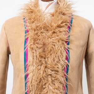 May include: A tan suede jacket with a long, fluffy brown fur collar. The jacket has a vertical stripe down the front, with pink, teal, and green accents.