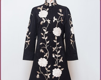 May include: A black long-sleeved jacket with a mandarin collar and white embroidered roses. The jacket has a fitted silhouette and a slightly flared hem.