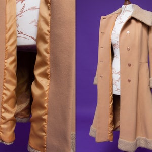May include: A long, camel-colored coat with a faux fur collar and lining. The coat has a double-breasted closure and a flared skirt.