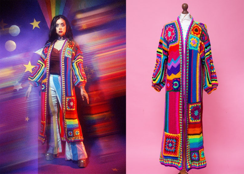 K&ouml;nnte beinhalten: Handgefertigter H&auml;kel-Duster-Mantel in Regenbogenfarben. Der lange, offen geschnittene Mantel hat quadratische und rechteckige Paneele mit floralen und geometrischen Mustern. Die &Auml;rmel sind lang und der Mantel wird auf einer Schaufensterpuppe pr&auml;sentiert.