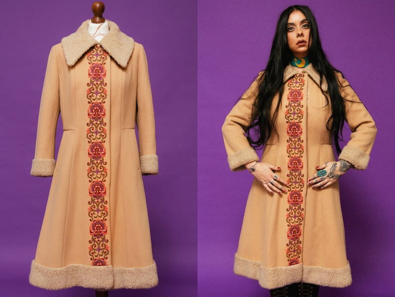 May include: A long, tan coat with a faux fur collar and cuffs. The coat has a floral embroidered design down the front.