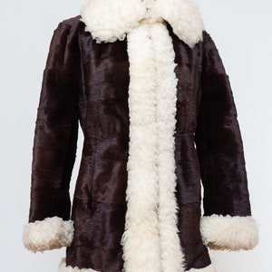 May include: A brown faux fur coat with a white faux fur collar and cuffs.