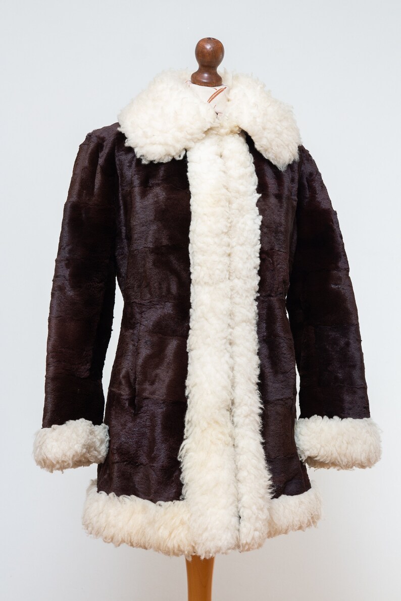 May include: A brown faux fur coat with a white faux fur collar and cuffs.