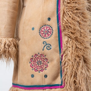 May include: A brown suede jacket with a long, shaggy fur collar and trim. The jacket features colorful embroidered designs with geometric patterns and sequins.