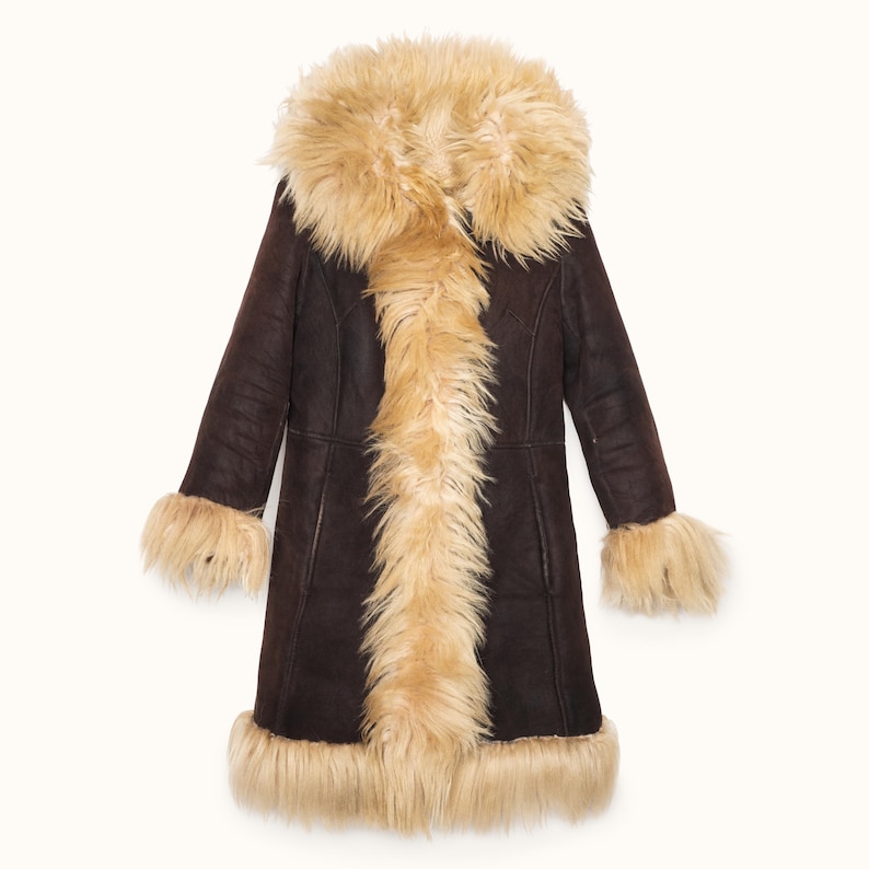 May include: A long, dark brown coat with a light brown fur collar, cuffs, and hem. The coat has a classic design with a button-up front and long sleeves. The fur trim adds a touch of luxury to this outerwear.