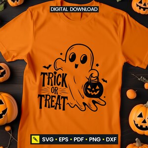 May include: Orange t-shirt with a black graphic of a friendly ghost holding a jack-o'-lantern bucket. The text "Trick or Treat" is below the ghost. The shirt is surrounded by carved pumpkins and small orange gourds, perfect for Halloween.