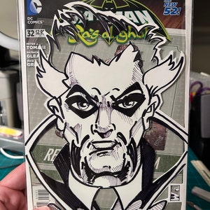 May include: A black and white illustration of a man's face with a serious expression. The illustration is cut out and placed on top of a comic book cover featuring Batman. The comic book cover is titled "Batman: The New 52!" and features the text "Rejuve Youth" at the bottom.