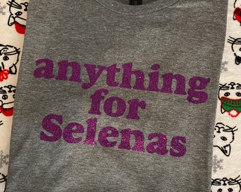 Op de afbeelding: Een grijs T-shirt met de tekst "anything for Selenas" in paarse glitterletters.