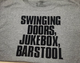May include: Gray t-shirt with black text that reads "Swinging Doors, Jukebox, Barstool".