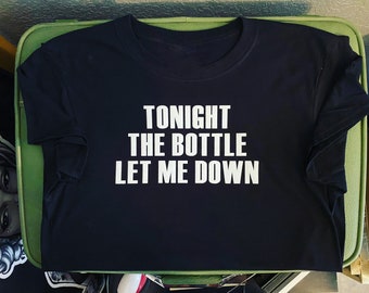 Op de afbeelding: Zwart T-shirt met witte tekst die "Tonight the bottle let me down" luidt.
