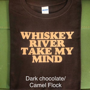 Peut inclure: Un t-shirt brun chocolat fonc&eacute; avec le texte "Whiskey River Take My Mind" imprim&eacute; en flocage camel sur le devant.