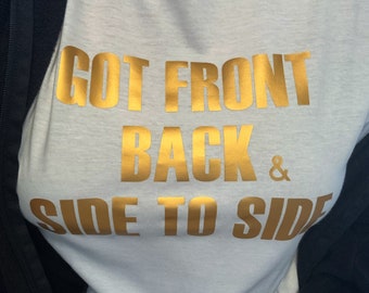Op de afbeelding: Wit T-shirt met gouden tekst "GOT FRONT BACK & SIDE TO SIDE". Het T-shirt met ronde hals is gemaakt van een zacht materiaal. De tekst is vetgedrukt, zonder schreef en gedrukt in goud.