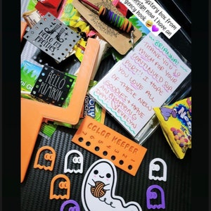 Puede incluir: Una peque&ntilde;a caja misteriosa llena de golosinas con tem&aacute;tica de Halloween, que incluyen dulces, un gancho de ganchillo y una nota escrita a mano que dice "BRIANNA! THANK YOU SO MUCH FOR YOUR CONTINUED SUP. PORT!! I HOPE YOU LOVE ALL OF THESE NEW GOODIES + HAVE AN AMAZING DAY! VEVELYN".