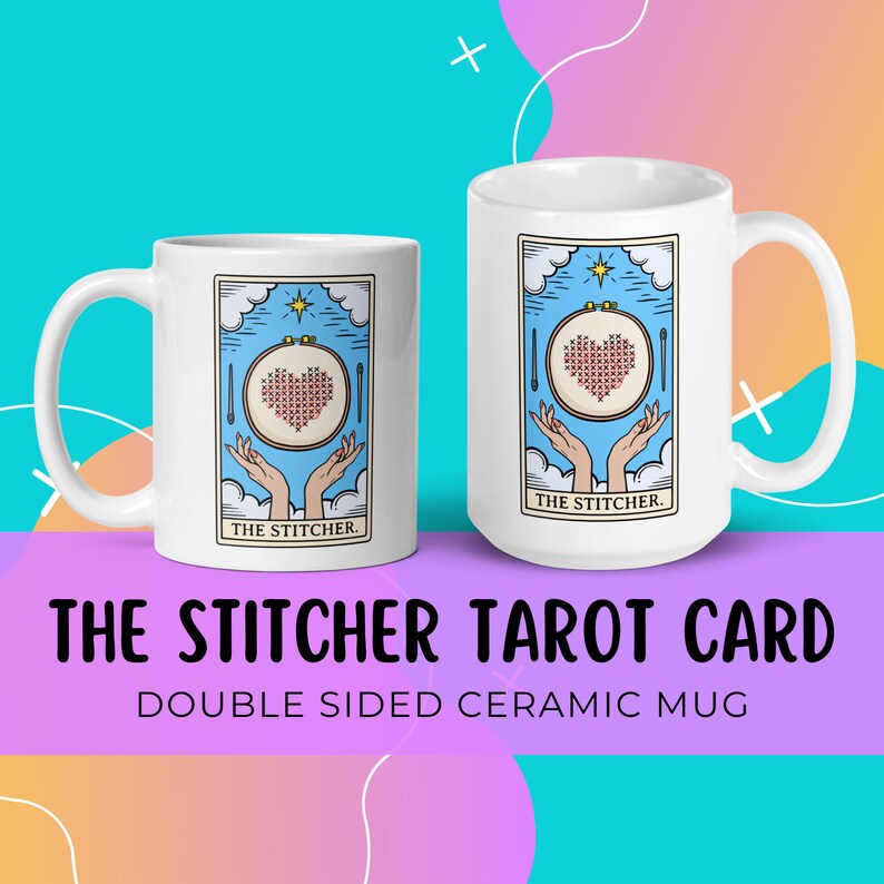 May include: White ceramic mug with a double-sided design. One side features a tarot card illustration of a hand holding a needle and thread with a heart-shaped cross-stitch in the center. The card reads "The Stitcher".