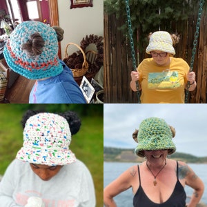 May include: Four crochet bucket hats in various colors and patterns. One is blue, white, and orange, another is white with colorful flecks, a third is yellow and white, and the last is green and yellow. Each hat has two decorative bun-like accents.