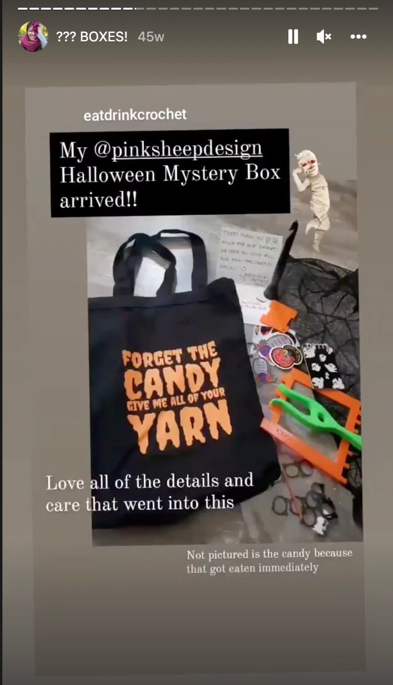 Puede incluir: Una bolsa de tela negra con el texto "Forget the Candy Give me all of your Yarn" en naranja. La bolsa est&aacute; llena de varios art&iacute;culos de tem&aacute;tica de Halloween, incluyendo pegatinas, un peque&ntilde;o fantasma de ganchillo y un par de agujas de tejer.
