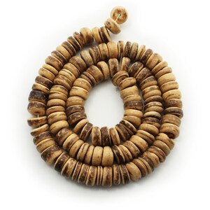 May include: A strand of brown and beige wooden beads, strung together in a circular shape.