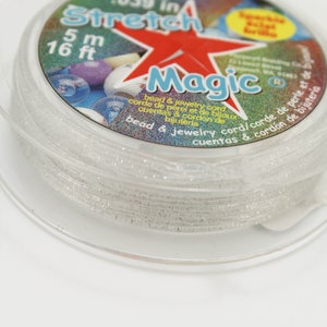 May include: A spool of clear, sparkly Stretch Magic bead and jewellery cord. The label indicates the cord is 1 mm thick and 5 m long (16 ft). The label features a red star and the word "Magic".