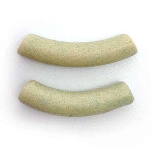 Può includere: Due pezzi curvi in ​​ceramica beige con una texture punteggiata.