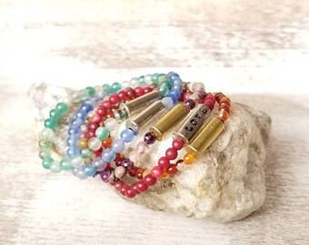 Brazalete elástico con cuentas con casquillo de bala calibre .22 y cuentas de piedra.