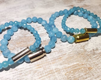 Brazalete elástico con abalorios calibre .22 o calibre .380 gastado con abalorios de gemas facetadas azules. Carcasas de latón o niqueladas.