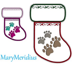 May include: Two white embroidered stockings with paw print designs. The smaller stocking has pink and teal paw prints with a pink cuff. The larger stocking has brown paw prints with a dark green cuff and red trim. The text MaryMeridius is in blue.