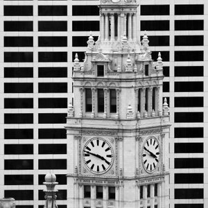 Puede incluir: Una foto en blanco y negro de una torre del reloj con dos esferas. La torre est&aacute; hecha de piedra y tiene un dise&ntilde;o decorativo. Las esferas son ambas redondas y tienen marcadores de hora romanos negros y manecillas negras.