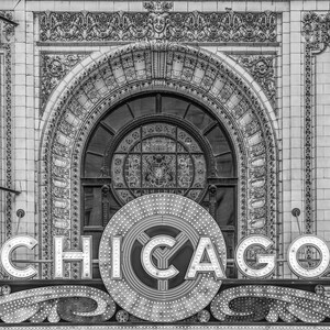 Puede incluir: Una foto en blanco y negro de un edificio con un gran arco ornamentado y un letrero que dice "CHICAGO" en letras blancas con bombillas.