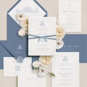 May include: Elegant wedding invitation suite in shades of blue and white. The suite includes invitations, RSVP cards, and envelopes, adorned with floral accents and a monogram. A blue ribbon ties the main invitation.