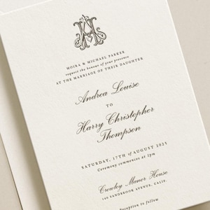 May include: Cream-coloured wedding invitation with a decorative monogram and classic script. The invitation details the names of the couple, the date, time, and venue of the ceremony, and reception information. The text reads: "Moira & Michael Parker request the honour of your presence at the marriage of their daughter..."