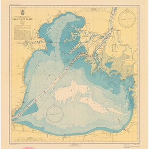May include: A vintage nautical chart of Lake Saint Clair, Michigan, with a light blue and beige color scheme. The chart shows the lake's shoreline, islands, and depths. Red dots mark various points of interest.