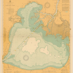 May include: A vintage map of Lake Saint Clair, Michigan, with a compass rose and depth soundings. The map is printed on a beige background with blue and green water features. The map includes the text "LAKE SAINT CLAIR" in the upper left corner.