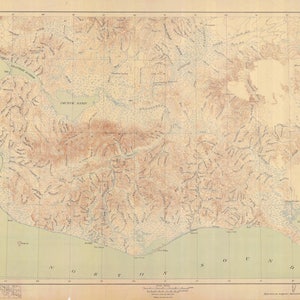 May include: A vintage map of the Alaskan Peninsula, showing the topography of the region. The map is printed on a cream-colored paper with brown lines indicating elevation and blue lines indicating rivers and streams. The map includes the names of various geographical features, such as "Fort Flamming", "Impek Lagoon", and "Cold Bay".