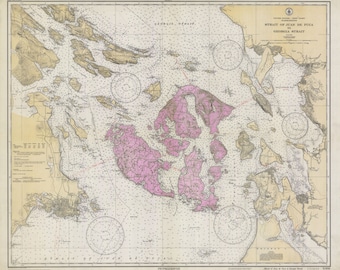 May include: A vintage map of the Strait of Juan de Fuca and Georgia Strait, showing the islands and waterways of the region. The map is in black and white with pink shading for land areas.
