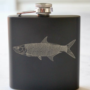 May include: Black stainless steel flask with a silver cap and a white line drawing of a tarpon fish.