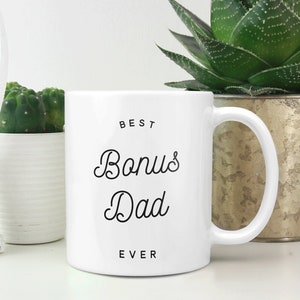 May include: White ceramic mug with black text that reads "BEST Bonus Dad EVER".