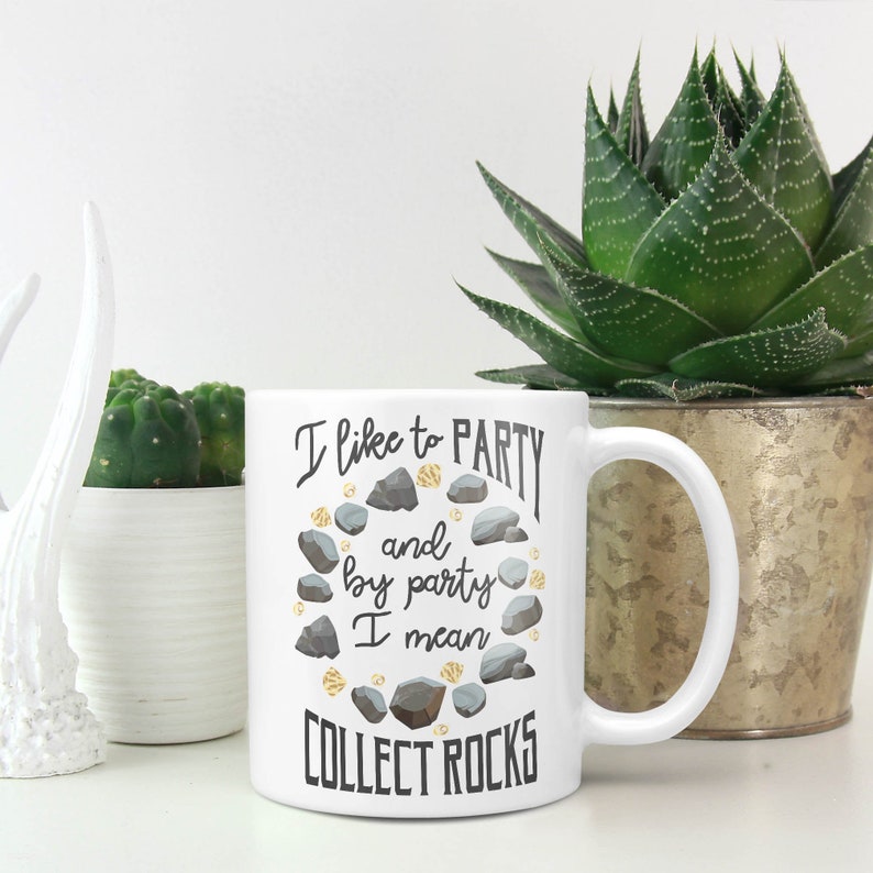 May include: White ceramic mug with a black and gold design. The mug says "I like to party and by party I mean collect rocks".