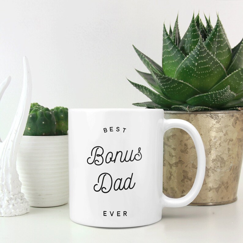May include: White ceramic mug with black text that reads "BEST Bonus Dad EVER".