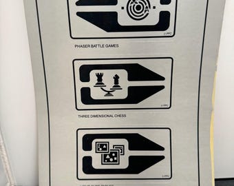 May include: A silver sheet with black graphics and text for "Phaser Battle Games," "Three Dimensional Chess," and "Light Cube Tables." The text "RECREATION DECK GRAPHICS" is at the bottom. The sheet has a yellowed edge.
