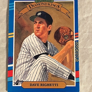 May include: A baseball card featuring Dave Righetti, a baseball player for the New York Yankees. The card is blue with a white border and features a picture of Righetti pitching. The card is from the Donruss Diamond Kings series.
