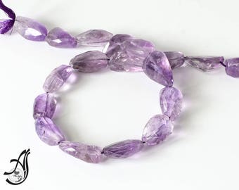May include: A strand of purple amethyst gemstone beads. The beads are faceted and have a natural, irregular shape. The beads are strung on a clear thread.