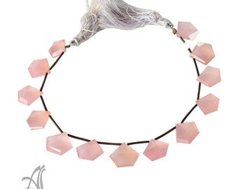 May include: A strand of pink gemstone beads with a tassel. The beads are faceted and have a light pink color. The beads are strung on a brown cord.