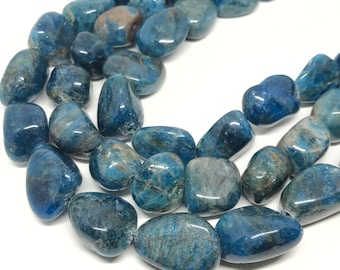 Puede incluir: Una hebra de cuentas de piedras preciosas azules y grises. Las cuentas son lisas y pulidas, y tienen un aspecto natural y orgánico.