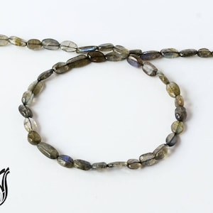 May include: A strand of oval-shaped labradorite beads in shades of gray and blue.