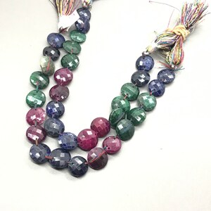 May include: A strand of faceted gemstone beads in shades of blue, green, and pink. The beads are round and have a polished finish.