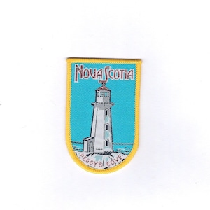 May include: A yellow and blue embroidered patch featuring a lighthouse and the text "Nova Scotia" and "Peggy's Cove".