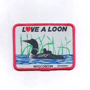 May include: An embroidered patch featuring a loon and the text "LOVE A LOON" and "WISCONSIN". The patch is red, white and green.