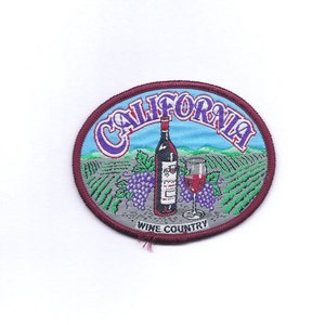May include: A burgundy oval-shaped patch with the text "CALIFORNIA WINE COUNTRY" in white. The patch features a cartoon illustration of a bottle of wine, a glass of wine, and grapes against a backdrop of a vineyard.