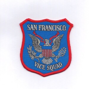 May include: A blue and red embroidered patch with the text "San Francisco Vice Squad" and a silver eagle with a shield and red ribbons.